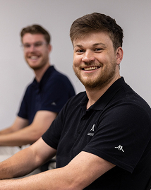 Two AI Advancements consultants smiling broadly together, representing the friendly and collaborative AI Strategy consulting team