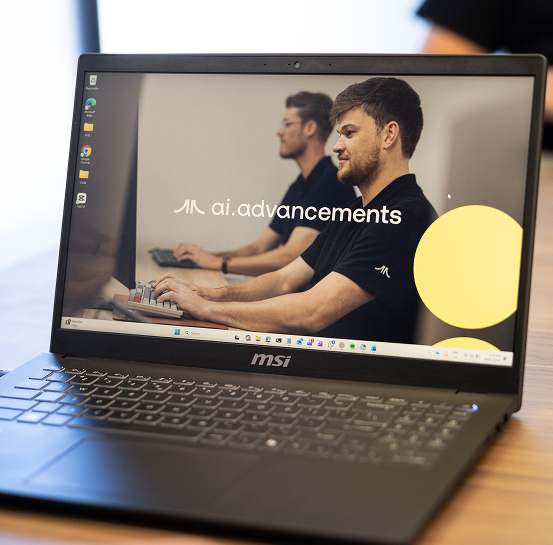 MSI laptop displaying AI Advancements brand logo with two developers working at computers in the background, representing AI for Developers training and development services