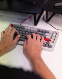 Close-up of hands typing on a keyboard representing the process to design the AI reporting agent