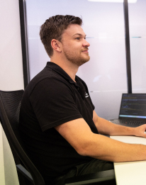 Professional in dark shirt working at a laptop, representing the AI implementation step to integrate with your data sources