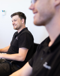 AI professional in dark shirt smiling during a consultation session, representing paid project scoping and technical planning services
