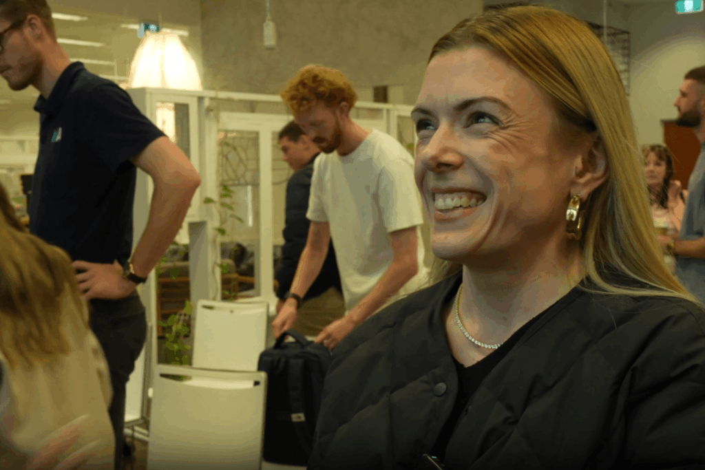 Woman with long light hair laughing with joy during a ChatGPT training workshop at Hampton Park Primary School with other training participants visible in the background